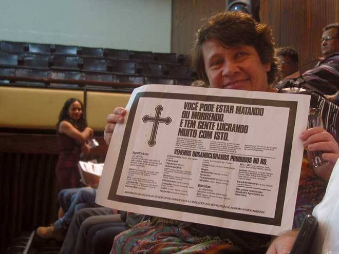 Lívia, filha da pioneira ambientalista Hilda Zimmermann, mostra um cartaz sobre a lei aprovada nos anos 80.